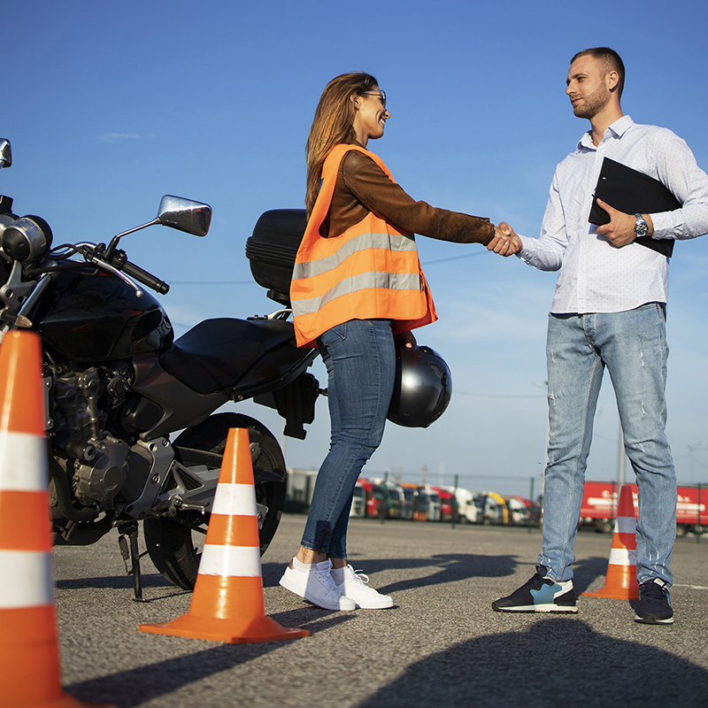 Motorcycle driving school. Instructor and student handshake befo